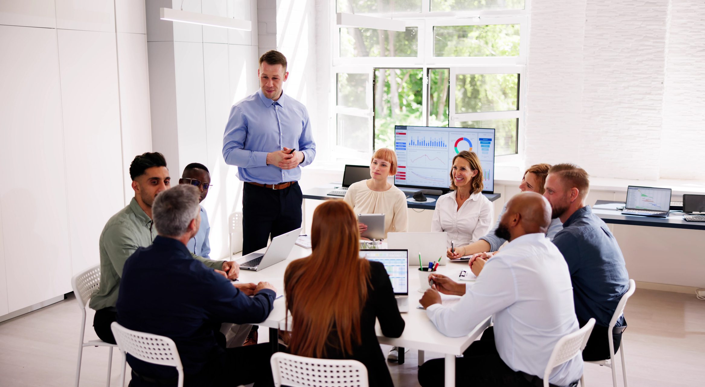 A sales leader presenting to a team around a conference table